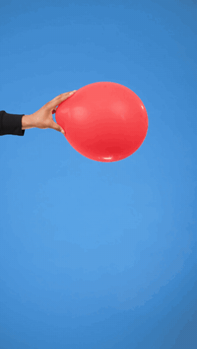 A Man In A Black Sweater Holds A Red Balloon In Front Of A Blue Background GIF