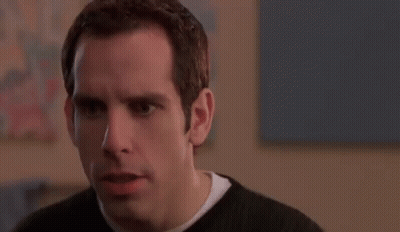 A Man In A Black Sweater Is Making A Funny Face And Looking At The Camera . GIF