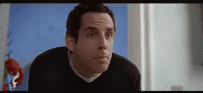 A Man In A Black Sweater Is Making A Funny Face In A Room . GIF