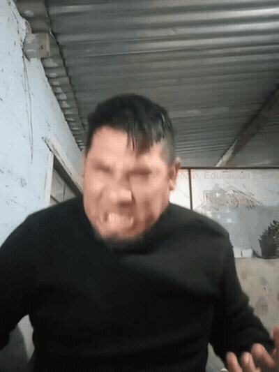 A Man In A Black Sweater Is Making A Funny Face GIF