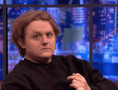 A Man In A Black Sweater Looks At The Camera GIF