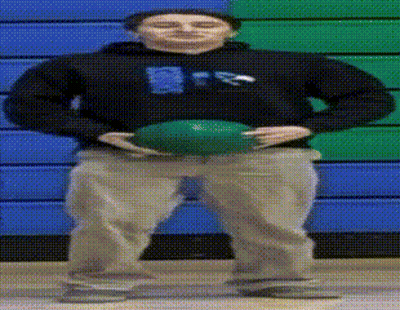 A Man In A Black Sweatshirt Holds A Green Ball In Front Of A Blue And Green Wall GIF