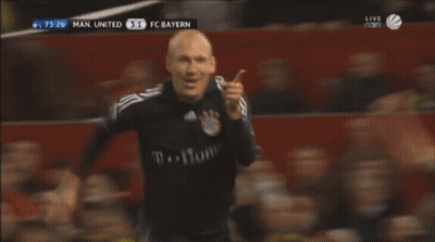 A Man In A Black T-Home Jersey Stands In Front Of A Crowd GIF