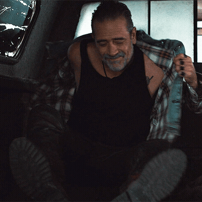 A Man In A Black Tank Top And Plaid Shirt Is Taking Off His Shirt GIF