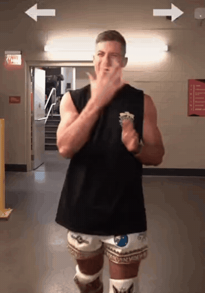 A Man In A Black Tank Top And White Shorts Is Dancing GIF