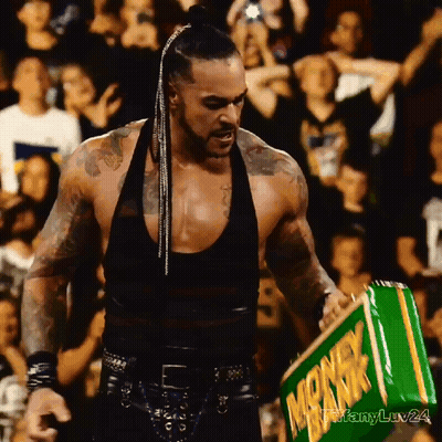 A Man In A Black Tank Top Holds A Green Box That Says Monkeyk GIF