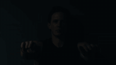 A Man In A Black Tank Top Holds His Hands Out GIF