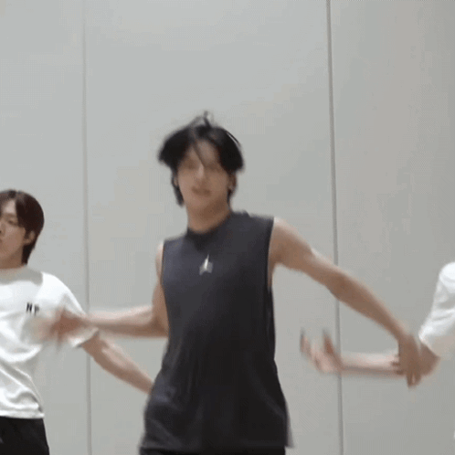 A Man In A Black Tank Top Is Dancing With Another Man GIF