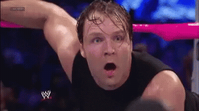 A Man In A Black Tank Top Is Laying In A Wrestling Ring With His Mouth Open And A Surprised Look On His Face . GIF