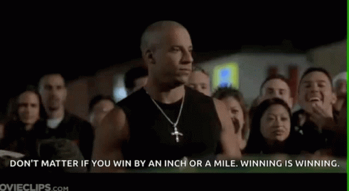 A Man In A Black Tank Top Is Standing In Front Of A Crowd . GIF