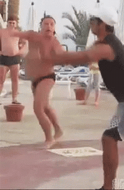 A Man In A Black Tank Top Is Standing Next To A Man In A White Hat . GIF