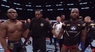 A Man In A Black Ufc Shirt Stands Next To Another Man GIF