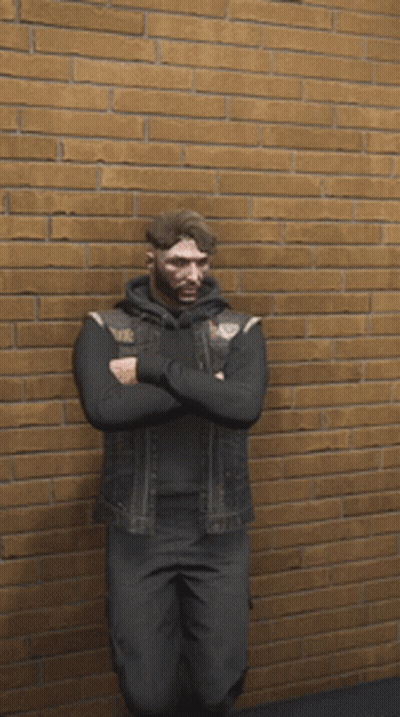 A Man In A Black Vest Is Standing In Front Of A Brick Wall GIF
