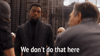 A Man In A Black Vest Is Standing In Front Of A Group Of Men And Saying We Don 'T Do That Here . GIF