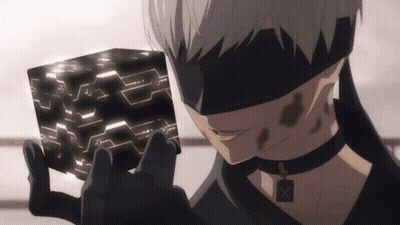 A Man In A Blindfold Is Holding A Black Cube In His Hands GIF