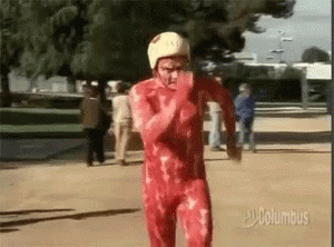 A Man In A Bloody Red Suit And White Helmet Is Running . GIF