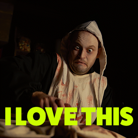 A Man In A Bloody Robe Is Holding A Piece Of Meat With The Words " I Love This " Above Him GIF