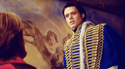 A Man In A Blue And Gold Military Uniform Is Standing In Front Of A Painting Of A Woman . GIF
