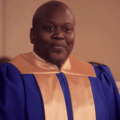 A Man In A Blue And Gold Robe Is Smiling For The Camera GIF