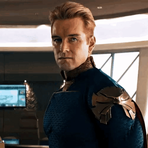 a man in a blue and gold superhero costume is standing in a room .