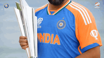 A Man In A Blue And Orange India Jersey Holds A Silver Trophy GIF