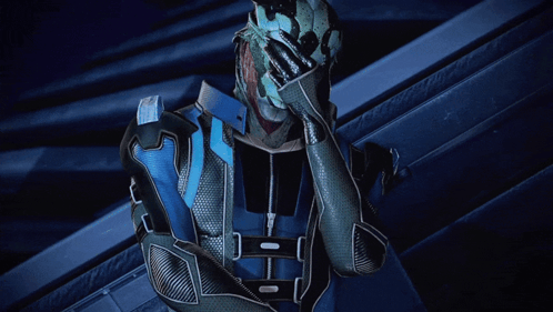 A Man In A Blue And Silver Suit Holds His Hand Over His Face GIF