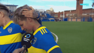 A Man In A Blue And Yellow Jersey Is Being Interviewed By A Microphone That Says Television Publico GIF