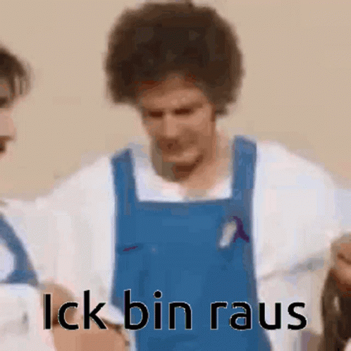 A Man In A Blue Apron Is Standing Next To Another Man In A White Shirt And Says `` Lick Bin Rau '' . GIF