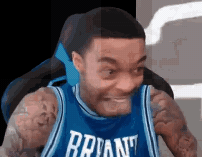 A Man In A Blue Basketball Jersey Is Making A Funny Face . GIF