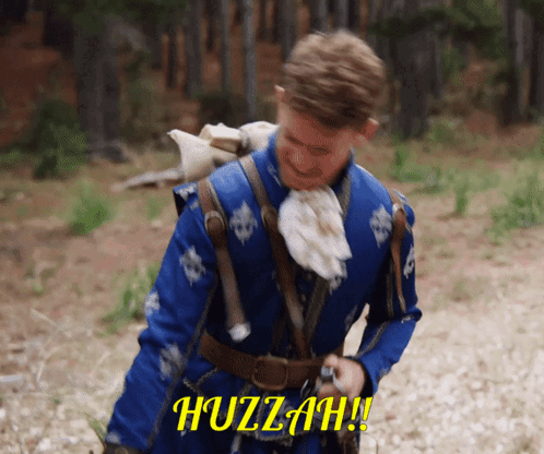 A Man In A Blue Coat Is Holding A Gun And The Word Huzzah Is On The Screen Behind Him GIF