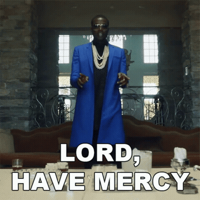 A Man In A Blue Coat Stands In Front Of A Table With The Words Lord Have Mercy On It GIF
