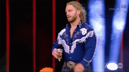A Man In A Blue Cowboy Shirt Is Holding A Drink GIF