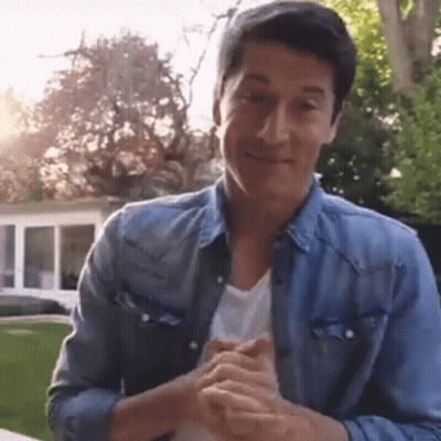 A Man In A Blue Denim Jacket Is Clapping His Hands . GIF
