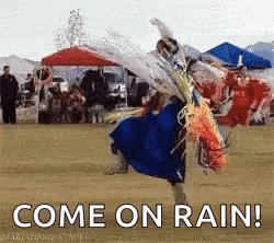 A Man In A Blue Dress Is Dancing In The Rain With The Words Come On Rain Written Below Him . GIF