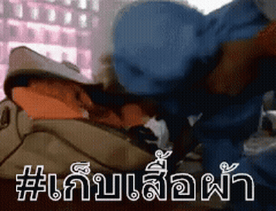 A Man In A Blue Hat Is Laying On A Bed With A Bag On His Head . GIF