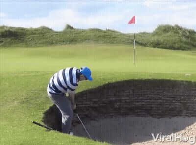 A Man In A Blue Hat Is Playing Golf On A Golf Course GIF