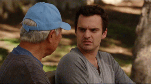 A Man In A Blue Hat Sits Next To Another Man GIF