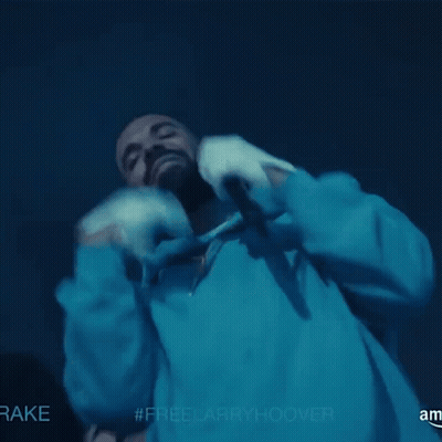 A Man In A Blue Hoodie Is Holding A Microphone With The Hashtag #Freelarryhoover On The Bottom GIF