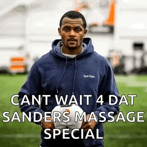 A Man In A Blue Hoodie Is Holding A White Hat With The Words Cant Wait 4 Dat Sanders Massage Special GIF