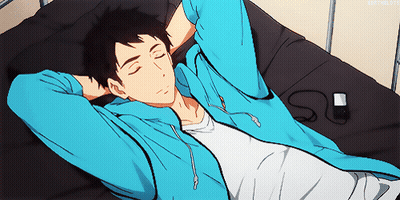A Man In A Blue Hoodie Is Laying On A Bed With His Eyes Closed GIF