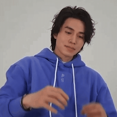 a man in a blue hoodie is making a funny face .