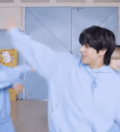 A Man In A Blue Hoodie Is Smiling And Looking At The Camera GIF