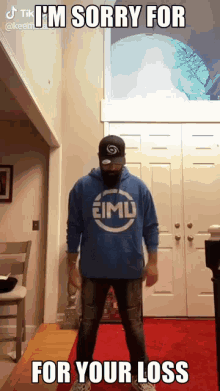 A Man In A Blue Hoodie Is Standing In A Room With A Caption That Says I 'M Sorry For Your Loss GIF