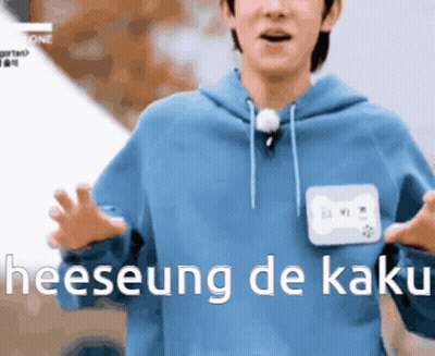 A Man In A Blue Hoodie With A Name Tag That Says Heeseung De Kaki On It GIF