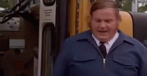 A Man In A Blue Jacket And Tie Is Sitting In Front Of A Truck And Says `` Good '' . GIF