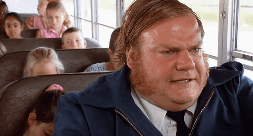 A Man In A Blue Jacket And Tie Is Sitting On A Bus GIF