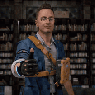 A Man In A Blue Jacket Giving A Thumbs Up In Front Of A Bookshelf GIF