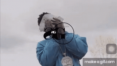 A Man In A Blue Jacket Is Covering His Face With Money And A Gun . GIF