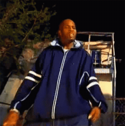 A Man In A Blue Jacket Is Dancing In Front Of A Basketball Hoop . GIF