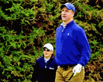A Man In A Blue Jacket Is Holding A Golf Club While Another Man Watches GIF